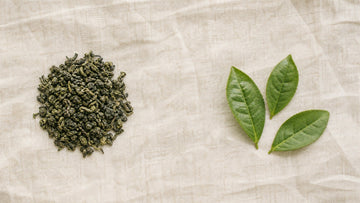 Hojas de té verde frescas y secas sobre lino